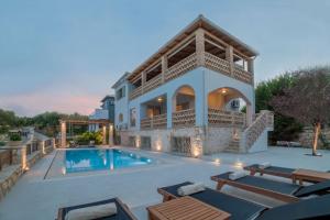 een villa met een zwembad en tuinmeubilair bij Villa Daphne in Tsilivi