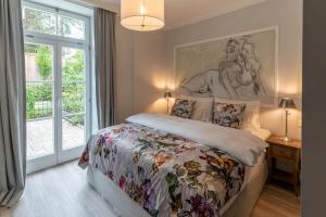 een slaapkamer met een bed met een schilderij aan de muur bij Villa Wickenburg in Salzburg