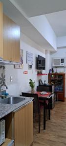 een keuken met een wastafel en een tafel bij Zhamira Avior's Condominium in Mactan