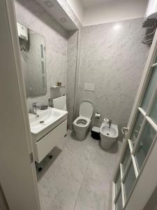 a white bathroom with a toilet and a sink at Boutique Hotel Whisky in Tirana