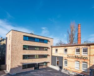 un edificio de ladrillo junto a un edificio con una fábrica en Mono Design Apartments en Stuttgart