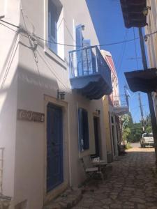 um edifício com uma porta azul e uma varanda em Kastellorizo- Casa Piero em Meyisti