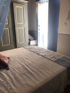 um quarto com uma cama, uma janela e uma porta em Kastellorizo- Casa Piero em Meyisti