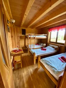 um quarto com duas camas e uma mesa num camarote em Górska Przystań em Wola Piskulina