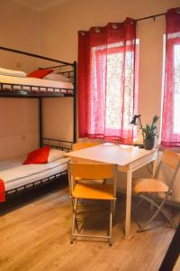 ワルシャワにあるArcus Premium Hostelの二段ベッド2台、テーブル、椅子が備わる客室です。