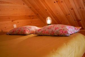zwei Kissen auf einem Bett in einem Zimmer in der Unterkunft Bungalow Blue - Cabana de Madeira in Nazaré