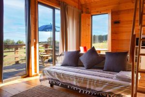 Schlafzimmer mit einem Bett und einem Balkon mit Fenstern in der Unterkunft Bungalow Blue - Cabana de Madeira in Nazaré