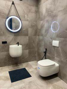 bagno con servizi igienici bianchi e specchio di Apartment Delmar Lux ЦЕНТР a Dnipro
