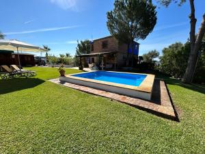 a swimming pool in the yard of a house at Casa Rural Cupiana Piscina privada Malaga in Málaga