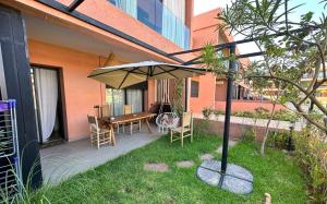 patio con ombrellone, tavolo e sedie di LDM Appartements Marrakech a Marrakech