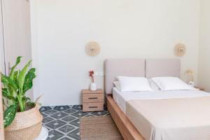 1 dormitorio con 1 cama y una maceta en Kosnian City Suites B, en Cos