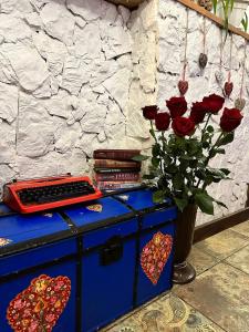a blue dresser with a vase of roses and books at WINE & ROSE BOUTIQUE HOTEL in Kharkiv