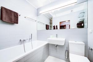 bagno bianco con lavandino, vasca e servizi igienici di Happy Apartment a Brno