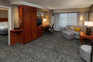 a hotel room with a couch and a bed and a desk at Courtyard by Marriott Lafayette in Lafayette