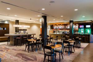 a restaurant with tables and chairs and a bar at Courtyard by Marriott Lafayette in Lafayette