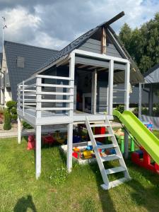a play house with a slide in the yard at U Wikinga - Domki letniskowe w Mielnie in Mielno