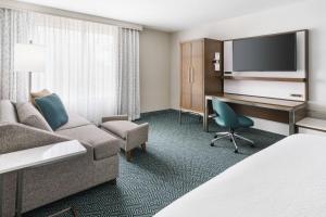 a hotel room with a couch and a desk with a computer at Courtyard by Marriott Orlando Downtown in Orlando