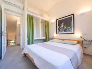 a bedroom with two beds and a painting on the wall at Casa Flaminia Villasimius in Villasimius