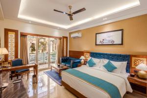 una camera d'albergo con letto, scrivania e balcone di HOTEL WHITE RABBIT a Pushkar