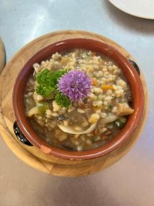 un tazón de sopa con una flor púrpura en él en Ruška koča, en Hočko Pohorje