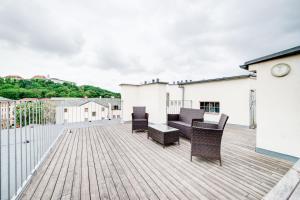 una terraza de madera con sillas y mesa en Happy Apartment, en Brno