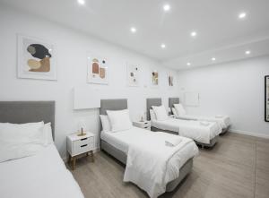 three beds in a room with white walls at No Limit Barcelona Central in Barcelona