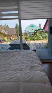 a bed in a bedroom with a view of a house at White House in Namhae