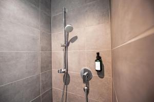 a bathroom with a shower with a bottle of soap at Mono Design Apartments in Stuttgart +23 photos