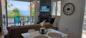 sala de estar con sofá, mesa y reloj en Seaview Luxury Apartment en Mitilene