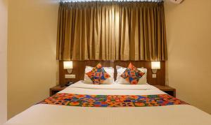 a bedroom with a bed with pillows and a window at FabHotel Royal International - Nr Mumbai International Airport in Mumbai
