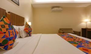a hotel room with a large bed with colorful pillows at FabHotel Royal Mumbai International Airport in Mumbai