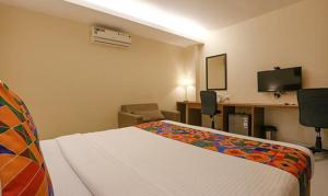 a hotel room with a bed and a desk and a television at FabHotel Royal Mumbai International Airport in Mumbai