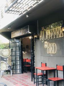 AJ Coffee & Bed في كورون: مطعم أمامه طاولات حمراء وكراسي