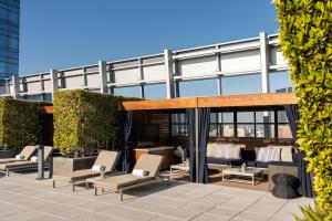 a patio with lounge chairs and a television in front of a building at The Ritz-Carlton, Los Angeles L.A. Live in Los Angeles
