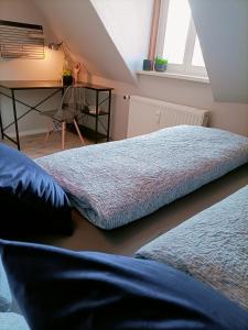 two beds sitting in a room with a desk at Bergsteigerbude in Wernigerode