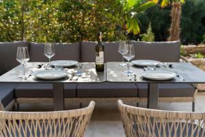 uma mesa com uma garrafa de vinho e copos em Altido Luxury Apartments em Budva