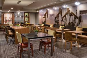 a restaurant with tables and chairs and a couch at Houston Marriott South at Hobby Airport in Houston