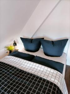 a bedroom with a bed with blue pillows on it at Bergsteigerbude in Wernigerode