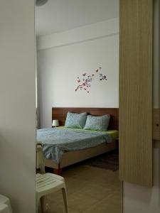 um quarto com uma cama com uma árvore na parede em Pensiunea Dea House em Constança