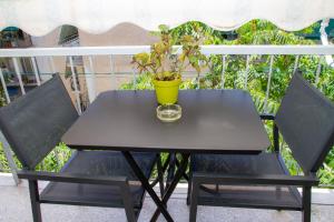 a black table and two chairs with a plant on it at AQA - No4, 360 degrees photos of the apartment to know exactly what you are booking in Athens