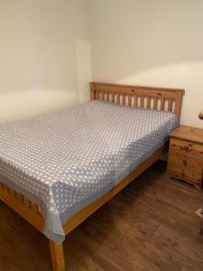 1 cama en un dormitorio con marco de madera en 360 Wolfe Stay, en Dungarvan