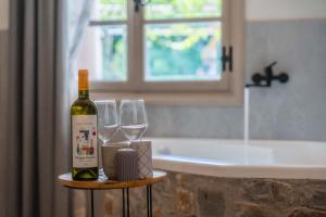 uma garrafa de vinho sentada numa mesa com copos de vinho em Krassopsychia Apartments em Krásion