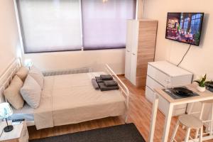 een klein appartement met een bed en een bureau bij URbAN DELUXE APARTMENTS AD in Thessaloniki
