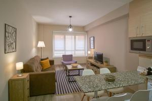 蓬費拉達的住宿－Apartamentos Los Arroyos，客厅配有沙发和桌子
