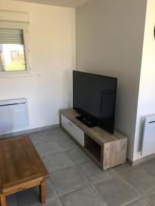 a living room with a flat screen tv on a table at Maison située entre plage la mine d'or et bourg in Pénestin