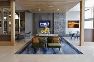 a living room with a table and chairs on a rug at Fairfield Inn & Suites by Marriott Mexicali in Mexicali