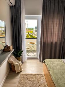 ein Schlafzimmer mit einem Bett und einer Tür zu einem Balkon in der Unterkunft Casa Nis - Apartament 2 dormitoare in Sibiu in Turnişor + 11 Fotos