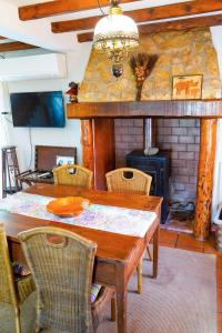 uma sala de jantar com uma mesa e uma lareira em Avó das Bolachas House em Famalicão