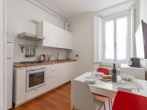 a kitchen with white cabinets and a table with chairs at The Best Rent - Spacious Two-bedroom apartment in Porta Romana in Milan