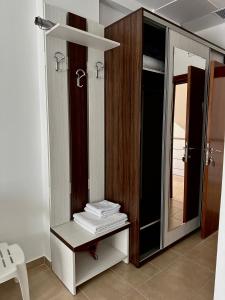 uma casa de banho com espelho e uma prateleira com toalhas em Pensiunea Dea House em Constança